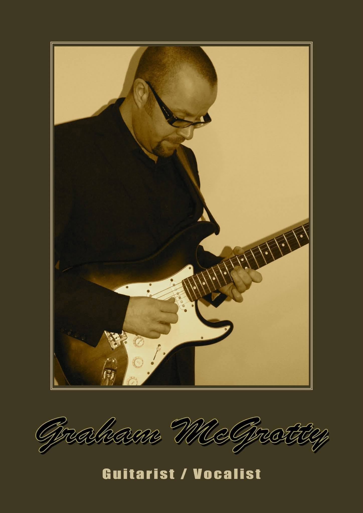 A sepia-toned photograph showing Graham McGrotty playing an electric guitar.